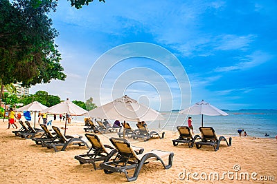 Lounge area with umbrellas and sun longers on a sandy beach against the blue sky Editorial Stock Photo
