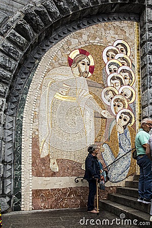 Lourdes, France, 24 June 2019: Mosaic of the studio of Marko Rupnik on the wall in front of the entrance to the Rosary Basilica in Editorial Stock Photo