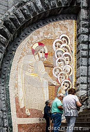 Lourdes, France, 24 June 2019: Mosaic of the studio of Marko Rupnik on the wall in front of the entrance to the Rosary Basilica in Editorial Stock Photo