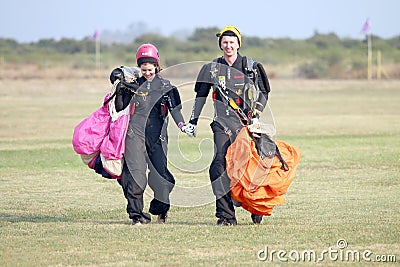 Love is in the air! Man and woman skydivers walking hand in hand Editorial Stock Photo