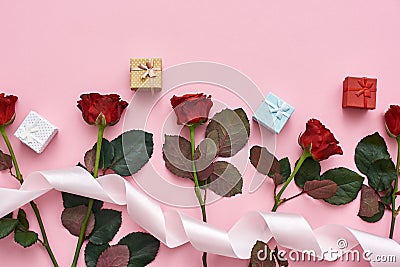 Love is a in the air. Red roses with cute colorful gist boxes and white ribbon on the top Stock Photo