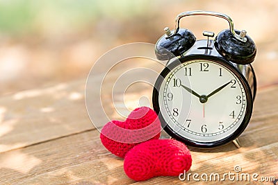 Love clock with heart on wooden table Stock Photo