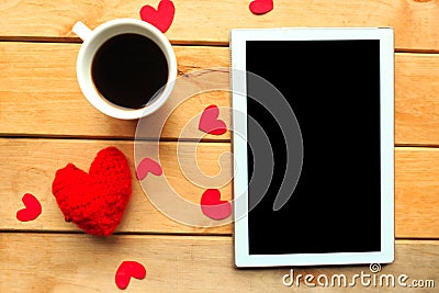 Love composition - coffee cup, tablet and craft heart on wooden background. Stock Photo