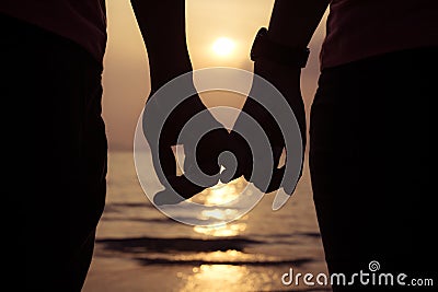 love couple holding hands fingers at sunset on the beach Stock Photo