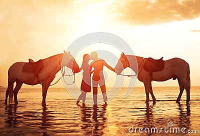 In love couple kissing on the beach. Two horses at sunset, summer scene. sunset in the sea Stock Photo