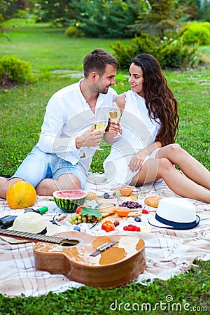 Love couple on Summer Picnic Basket on the Green Grass. Food and Stock Photo