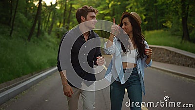 Love couple walking on road. Joyful girl and guy jumping on road outdoors. Stock Photo