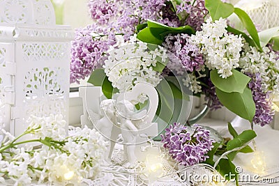 Love decor with angels and bunch of lilac blossoms on window sill Stock Photo