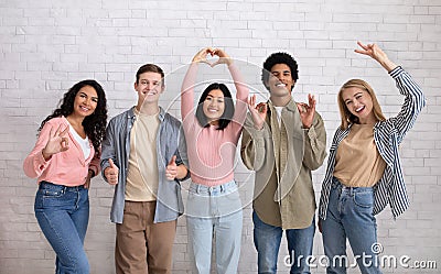 Love, friendship, youth, lifestyle. Teen happy multiracial friends gesturing with hands Stock Photo