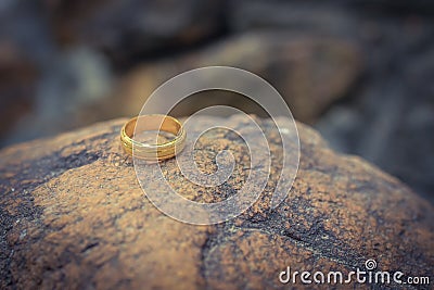 Love gold ring put on rock vintage style Stock Photo
