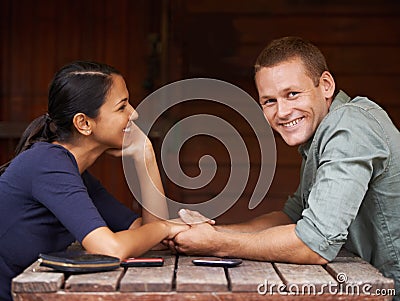 Love, holding hands and couple at a cafe with support, care and trust while bonding outdoor together. Marriage, romance Stock Photo