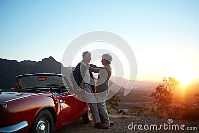 Love lead them here. an affectionate senior couple enjoying the sunset during a roadtrip. Stock Photo