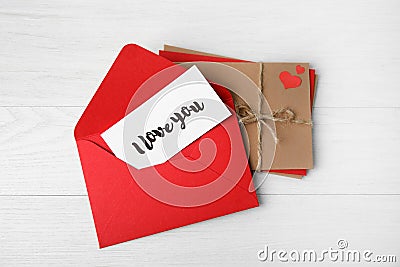 Love letter and stack of envelopes on white wooden background, flat lay Stock Photo