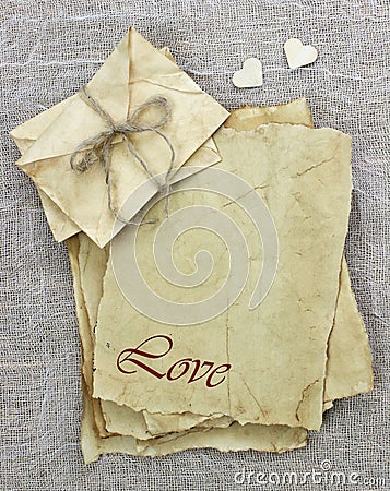 Love letters and envelopes made of antique parchment paper with wooden hearts on background Stock Photo