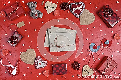 Love letters surrounded by gifts, hearts and other love objects on red background Stock Photo