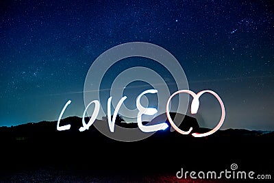 Love light paining alphabet over Stars in the night sky background. Stock Photo