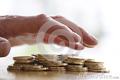 Greedy hand grabbing or reaching out for pile of golden coins. Close up - Concept for tax, fraud and greed Stock Photo