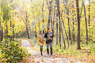 Love, parenthood, family, season and people concept - smiling couple with baby in autumn park Stock Photo