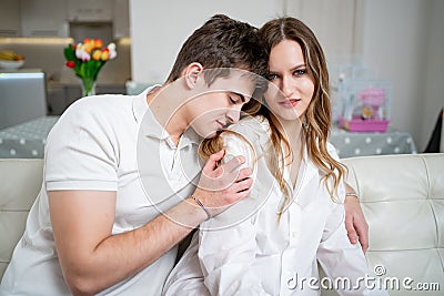 love, passionate and beautiful couple gently cuddled on a white sofa Stock Photo