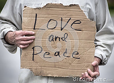 Love and Peace handwritten cardboard sign, man holding, closeup Stock Photo