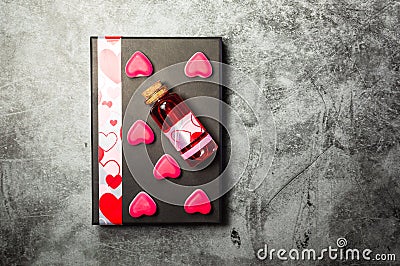 Love potion and heart shaped sweets on a gift box Stock Photo