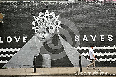 Love saves graffiti of Hanna Lucatelli a Brazilian artist on Hanbury Street off Brick Lane Editorial Stock Photo
