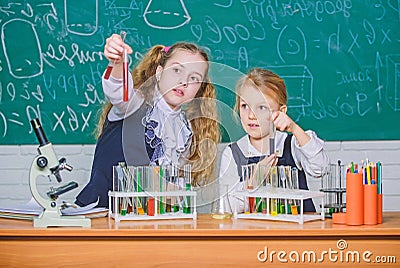 We love science. School children performing experiment in science classroom. Little girls scientists holding test tubes Stock Photo