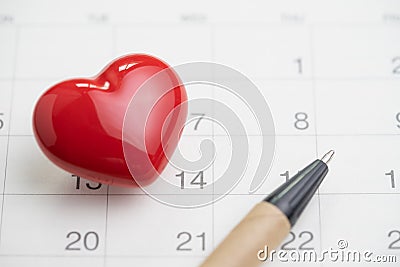 Love symbol or romance of valentine`s day concept with shiny red lovely heart shape with pen on 14 Feb white clean calendar Stock Photo