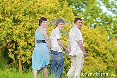 Love and Tenderness Concepts and Ideas. Caucasian Family of Three Spending Time Together Embraced in Summer Park Stock Photo