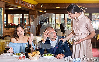 Love triangle - wife caught husband with mistress in restaurant Stock Photo
