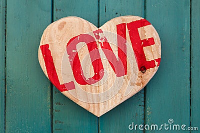 Love Valentines message wooden heart on turquoise painted background Stock Photo