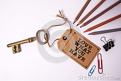 Love what you have. Price tag with text and golden key on white background Stock Photo