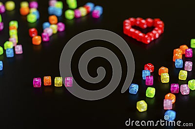 Love word folded with colorful cubes with letters and a heart on a black background Stock Photo