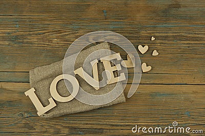 Love word, small hearts on dark wood background. Top view of Valentine`s Day Stock Photo