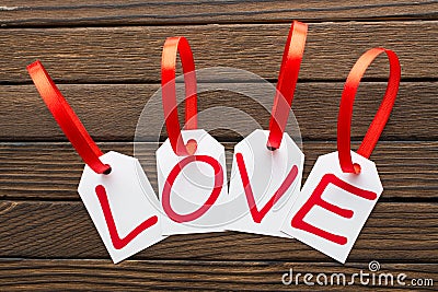 Love word is written in the white tags the wooden background. Stock Photo