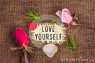 Love yourself written in hole on the burlap Stock Photo