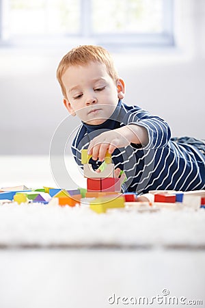 Lovely 3 year old playing with cubes at home Stock Photo