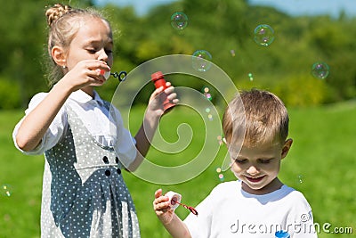 Lovely children blow soap bubbles Stock Photo