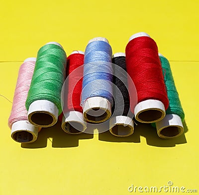 Colorful yarns on the yellow background. Stock Photo