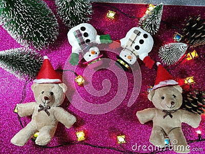 Lovely couple bear and snowman on pink gliter background near ornament lighting bulb at silent night, holy night, Merry Chr Stock Photo
