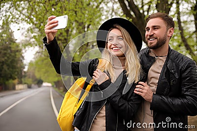 Lovely couple with smartphone taking selfie on spring day Stock Photo