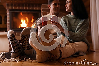 Lovely couple with sweet cocoa near fireplace, focus on legs Stock Photo