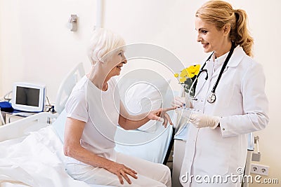 Lovely experienced doctor bringing her patient new pills Stock Photo