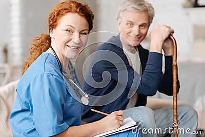 Lovely experienced therapist diagnosing her patient at home Stock Photo
