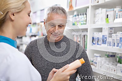 Lovely female pharmacist helping her client Stock Photo