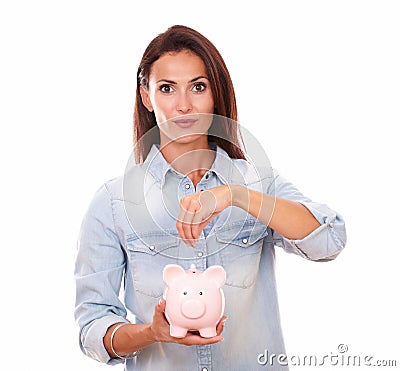 Lovely latin lady savings money in a piggybank Stock Photo