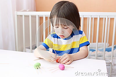Lovely little boy made toothpick legs by playdough spiders Stock Photo