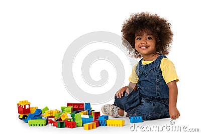 Cute little african american girl playing with lots of colorful plastic blocks indoor. Isolated Stock Photo