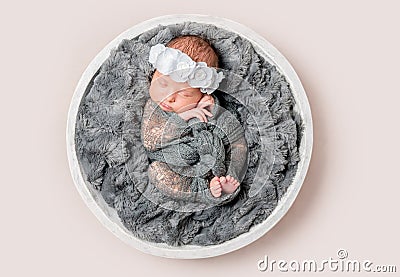 Lovely little girl sleeps on round basket, top view. Stock Photo