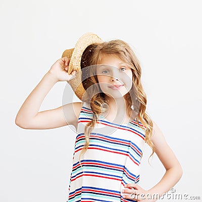 Lovely little girl with straw hat and striped dress against a white background. Stock Photo